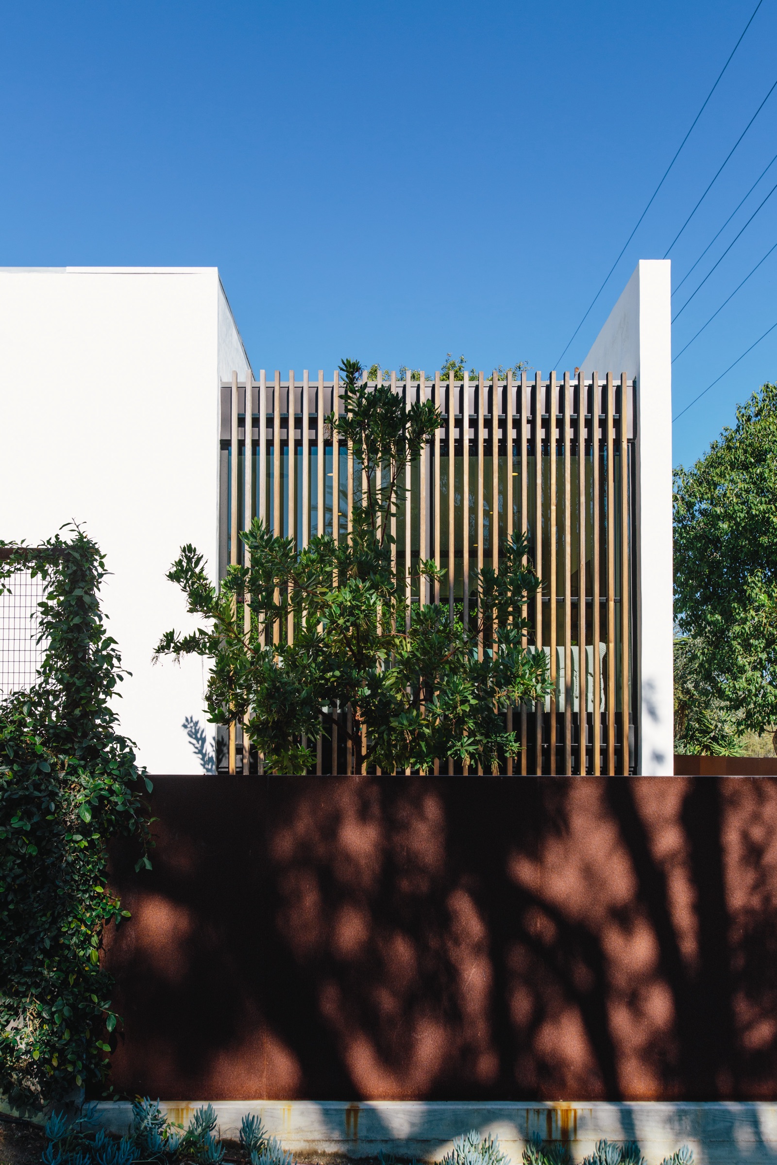 32nd Street — slatted wood screen above a corten wall