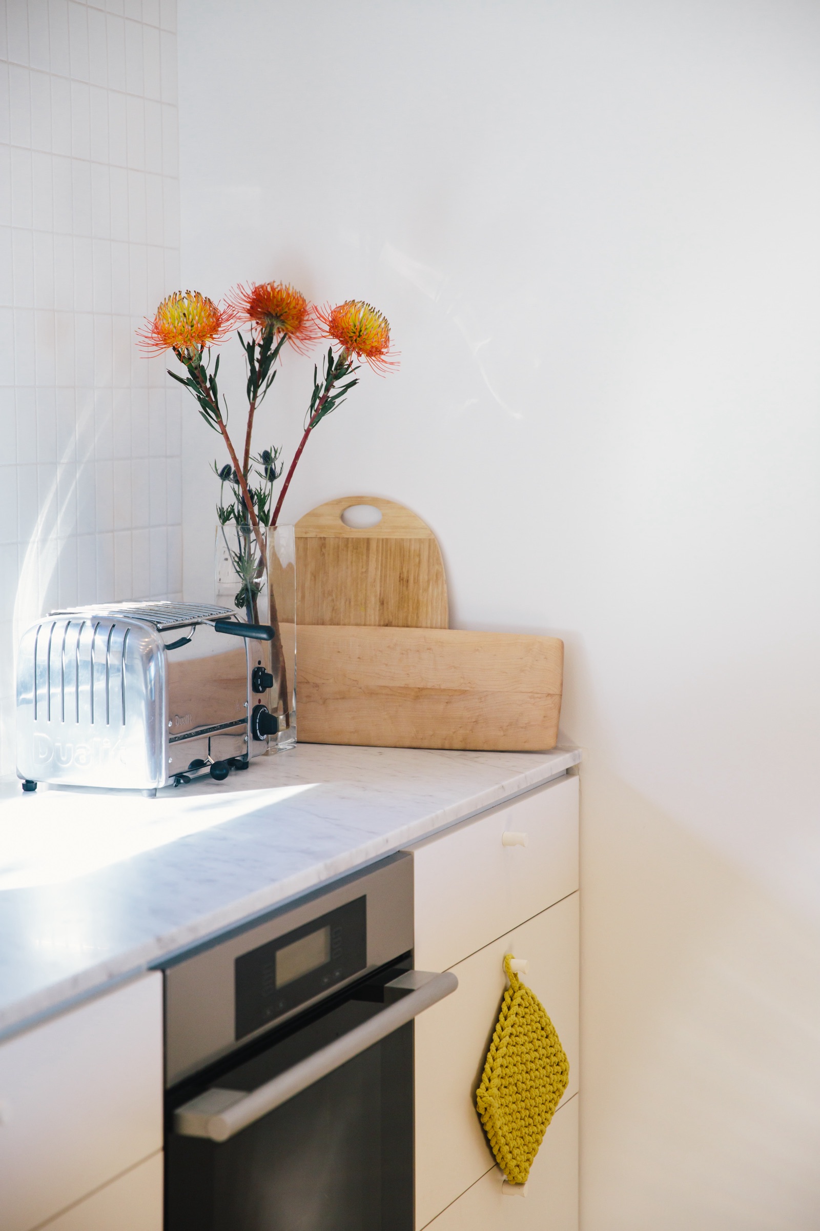 Kitchen corner with marble counter, cutting boards, and protea flowers