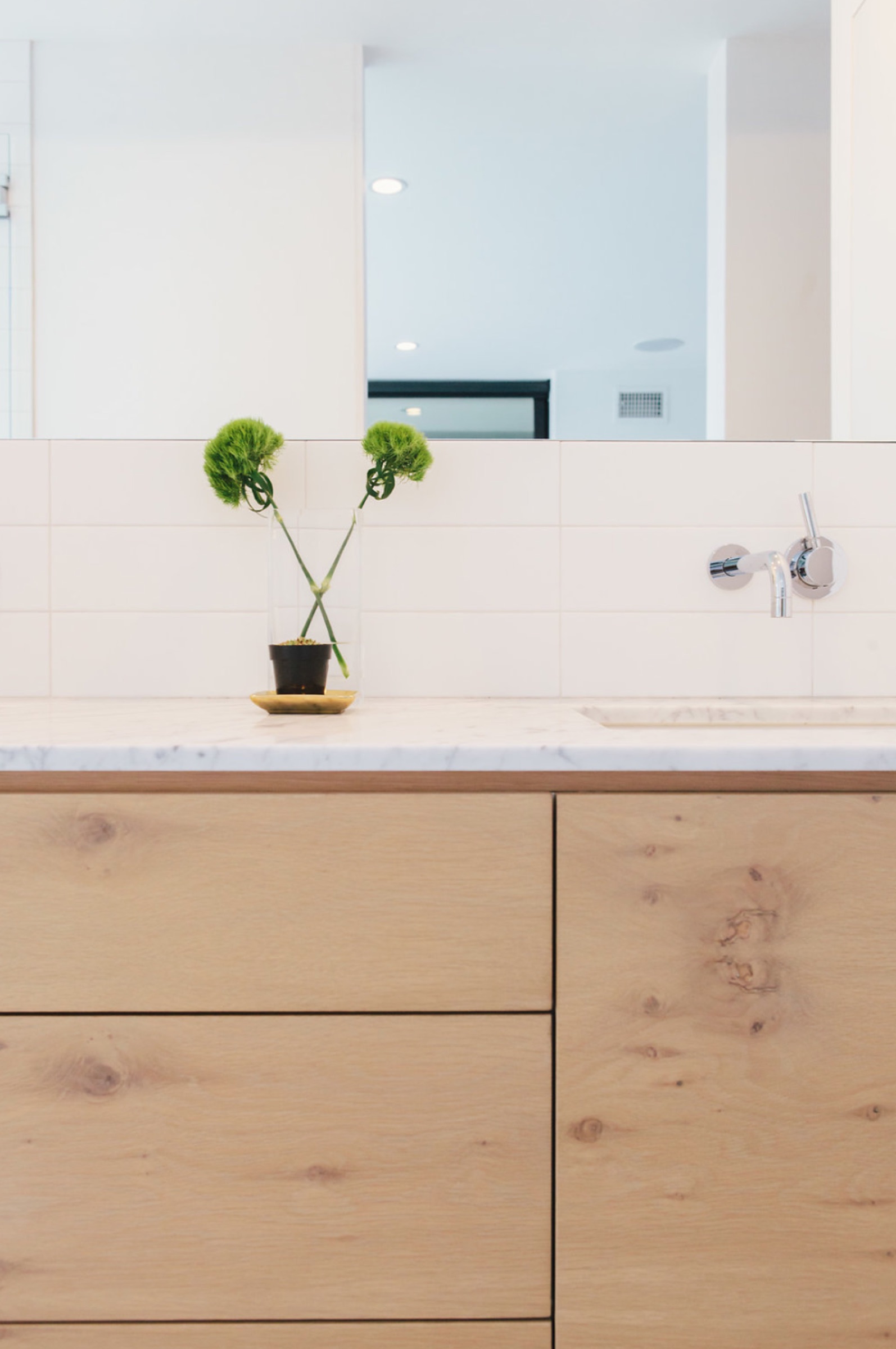 Oak vanity with marble top and wall-mounted faucet
