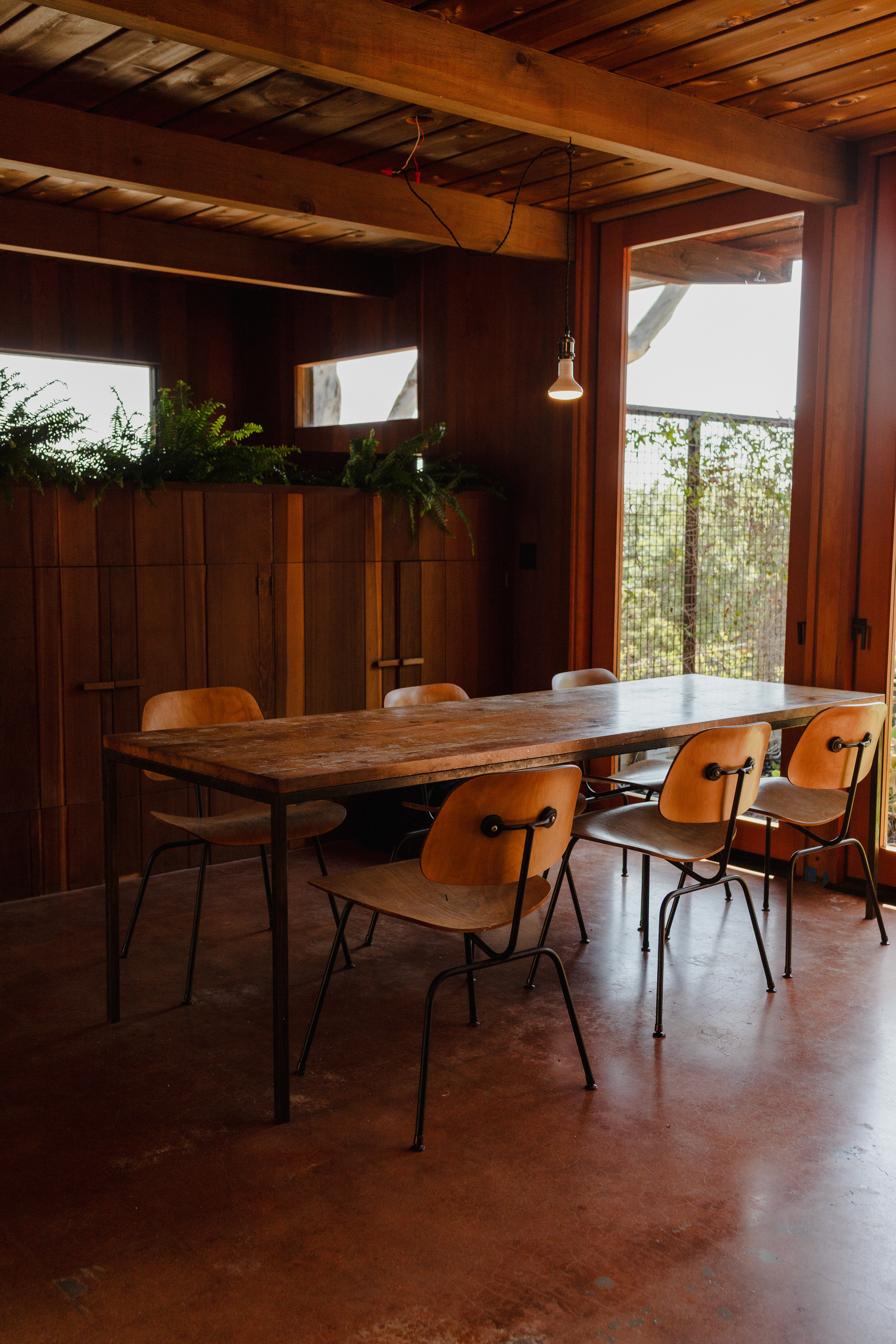 Interior dining room with Eames chairs and redwood paneling