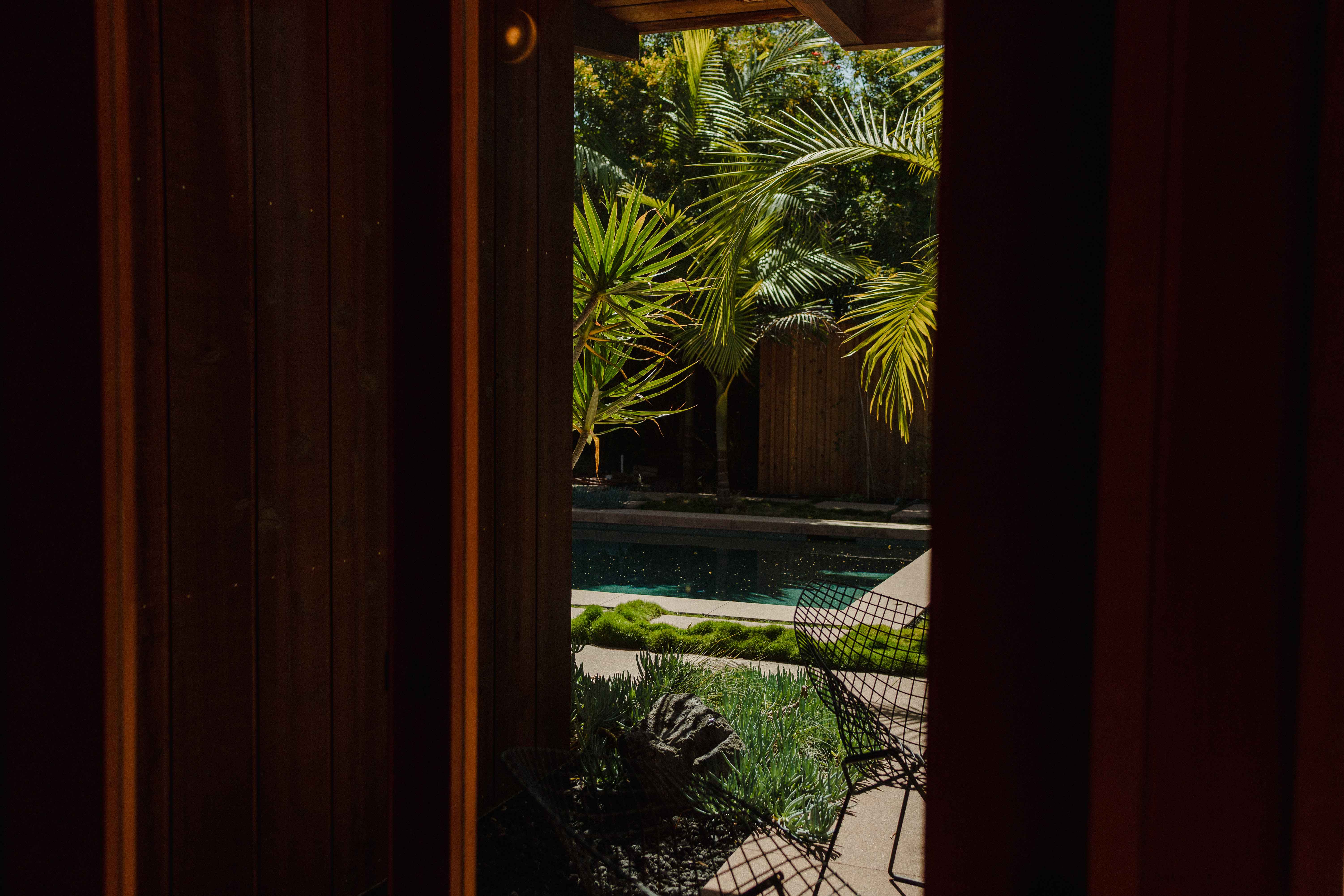 View through doorway to pool with Bertoia chair